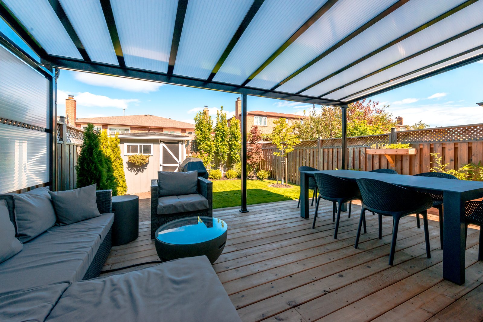 Louvered patio cover with adjustable slats over outdoor lounge and dining area